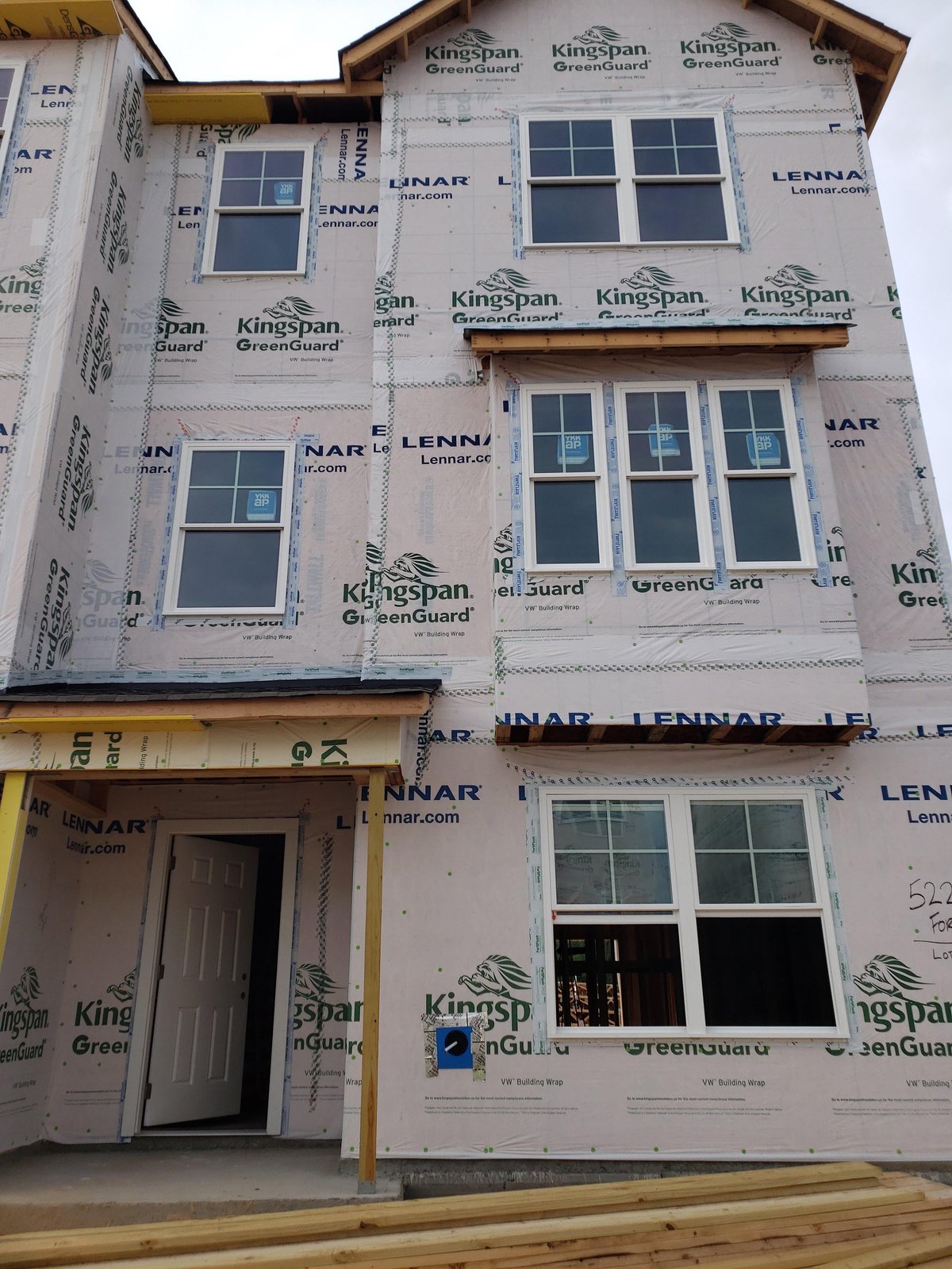Two-story home under construction with multiple new window installations