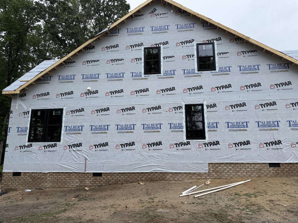 House under construction with Tyvek wrapping and new window installations