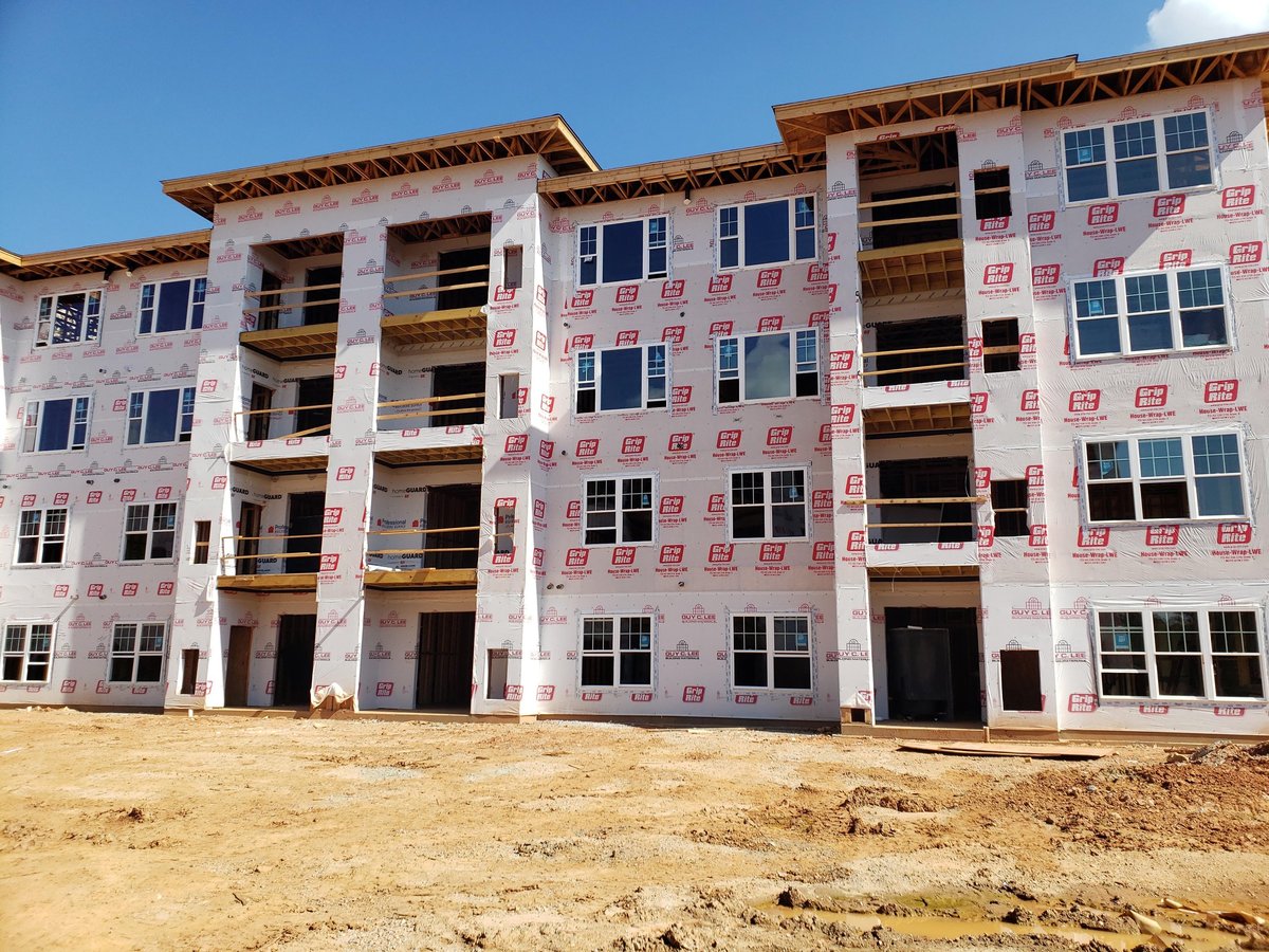 Multi-story residential building with new window installations across multiple units